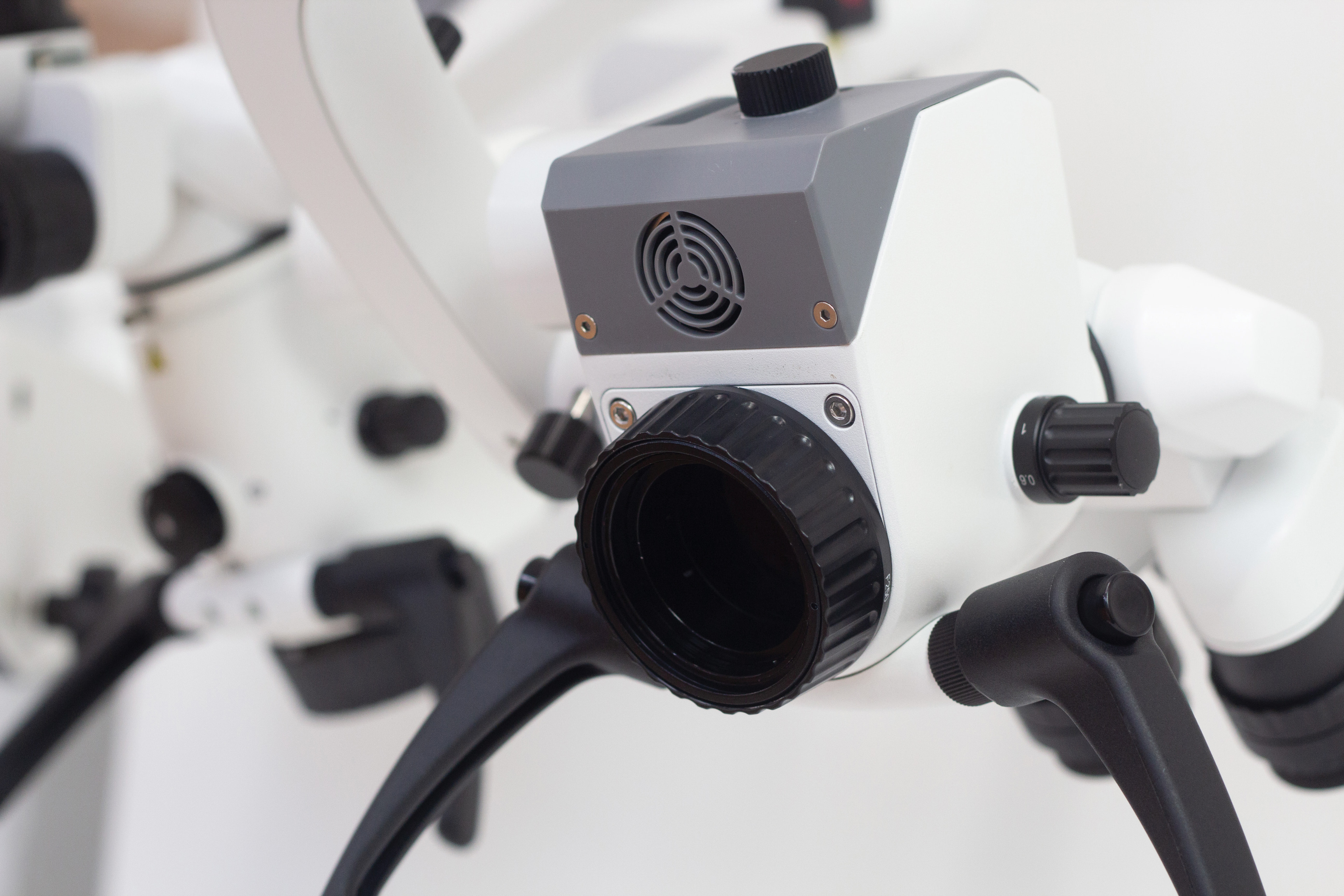 Front optical assembly of a white surgical simulation microscope